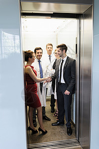 商务握手电梯中的医生和商人背景