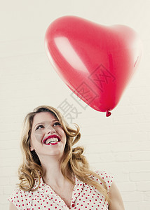 看着心形气球微笑的女人图片