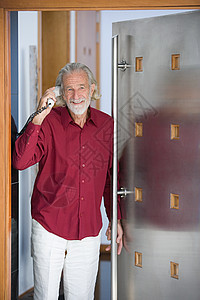 靠在门边接电话的老年男人图片
