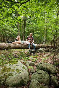 一对夫妇坐在大树上休息图片