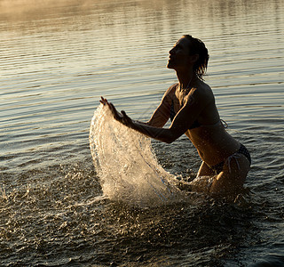 妇女在湖水中泼水图片