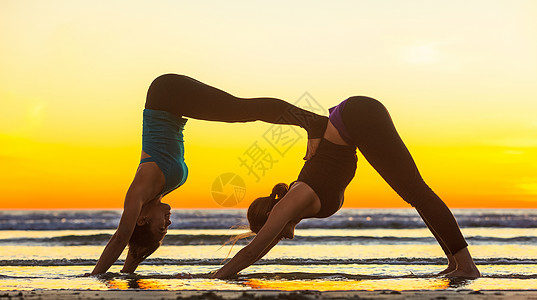 年轻女性在海滩上做瑜伽图片