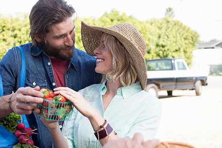 在农民市场上买草莓的夫妇图片
