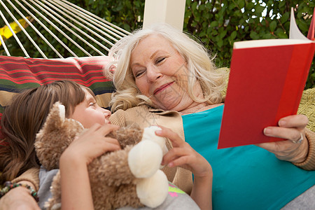 祖母和孙女在吊床上读书图片
