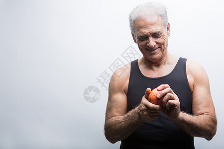 退休老人拿着苹果微笑图片