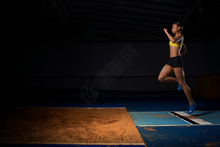 年轻女运动员跳长图片