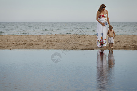 母亲和幼儿向水中看倒影图片