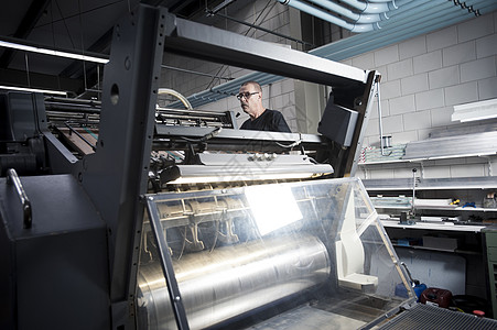 印刷车间工人操作印刷机图片