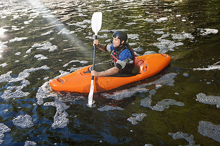 成人中年男子在平静的河上划皮艇图片