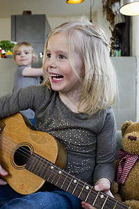年轻女孩弹奏音乐吉他图片