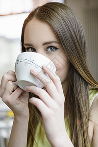 在室内喝咖啡的年轻女子近景肖像图片