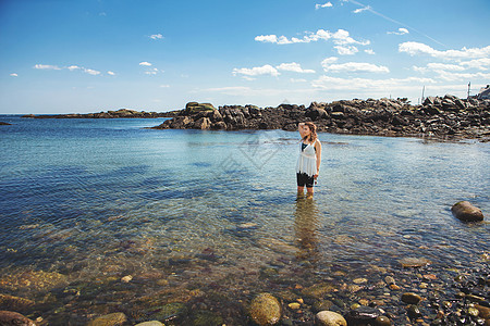 美国缅因州比德福海滨岩石岸滩的中年轻女图片