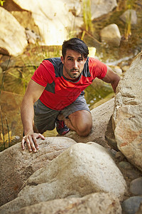 年轻男自由登山者攀岩石图片