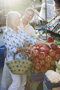 在市场上选购蔬菜的夫妇图片
