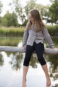 塞里木湖女孩坐在木栅栏上看着湖下背景