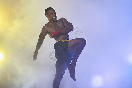 健身肌肉男在聚光灯和雾中拍摄肌肉男拳击手背景