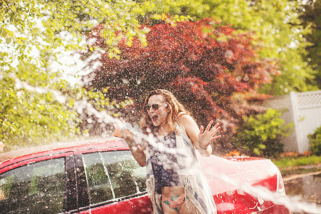户外洗车玩水的年轻女性图片