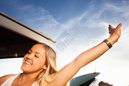 年轻的女冲浪者在皮卡车上伸展身体图片