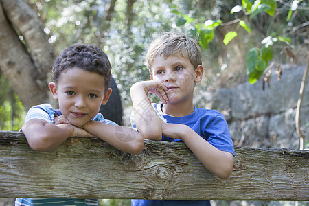 靠在花园围栏上的两个男孩分享高清图片素材