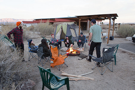 坐在美国加利福尼亚州安扎博雷戈沙漠州公园营火周围聊天的年轻人图片