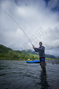 美国阿拉斯加河上捕鱼的男子图片