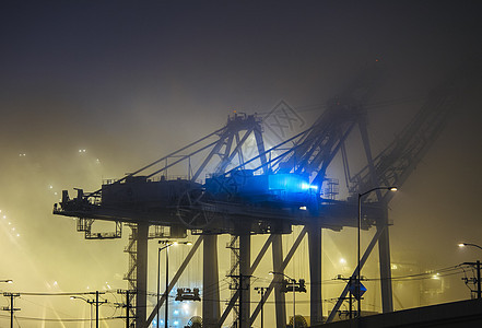 美国华盛顿州西雅图夜间港口起重机的朦胧景色图片
