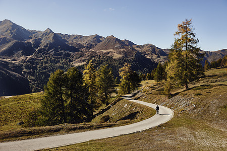 远山区公路上骑山地自行车的骑行者图片