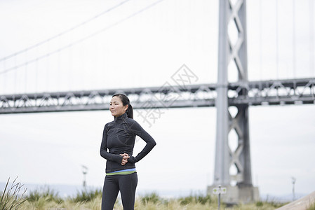 女跑者在加利福尼亚旧金山桥下休息图片
