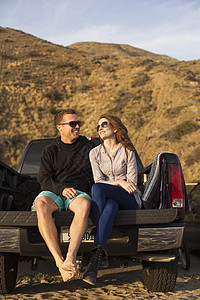 海滩长凳上坐着的情侣图片