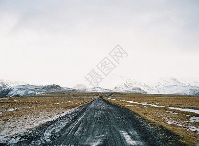 公路上的雪和遥远的雪山峰图片