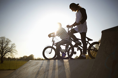 两个年轻人骑着自行车在滑板公园图片