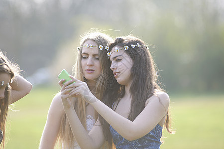 手机拍照两个少女在公园使用手机背景