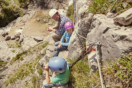 攀岩父亲和孩子们享受着对岩石的观光背景