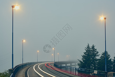 挪威罗加兰县豪格松街道灯光照明下迷雾道路的渐弱透视图背景图片