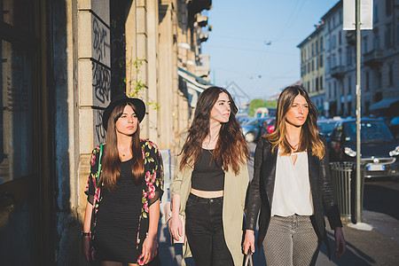 三名年轻妇女在市街上漫步图片