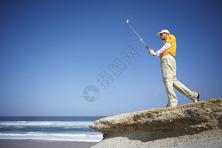 海边打高尔夫的男子图片