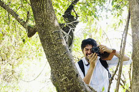 从赞比亚树上使用相机拍摄的成年男子图片