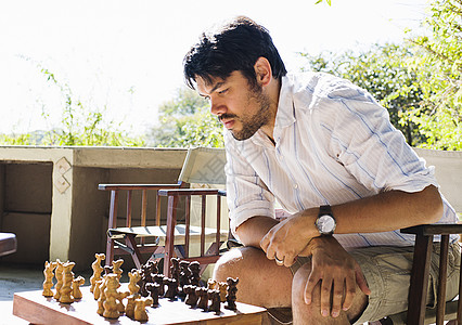 在赞比亚公园的小屋下象棋的中年成人男子高清图片