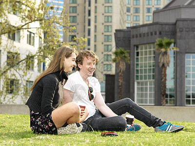 在草地上喝咖啡的年轻夫妇澳大利亚墨尔本维多利亚毛衣高清图片素材