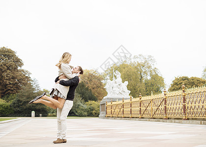 浪漫的年轻男性在公园举起女朋友年轻夫妇高清图片素材