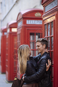 一对浪漫的年轻情侣在红色电话亭旁拥抱图片