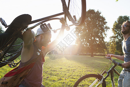 日落时两名男朋友乘自行车来到公园图片