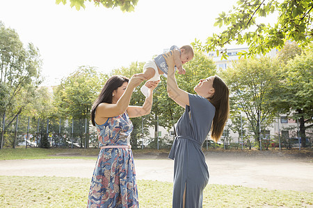年轻妇女和母亲在公园里抱着女婴图片