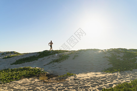 年轻人沿着沙丘奔跑图片
