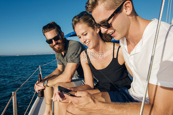 在帆船上使用智能手机的夫妇图片