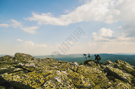 在俄罗斯崎岖的地貌岩石上徒步旅行的男者图片