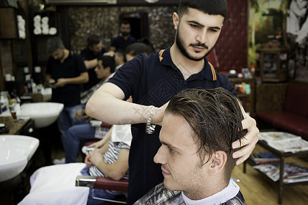理发店师剪年轻男人的头发图片