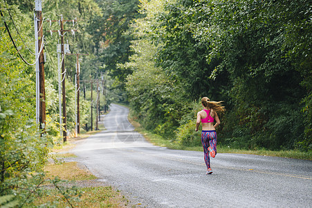 少年女跑步者在农村路上的近视图片