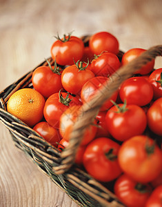 新鲜小番茄和柳篮中的橙子图片