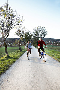 在小路上骑自行车的情侣图片